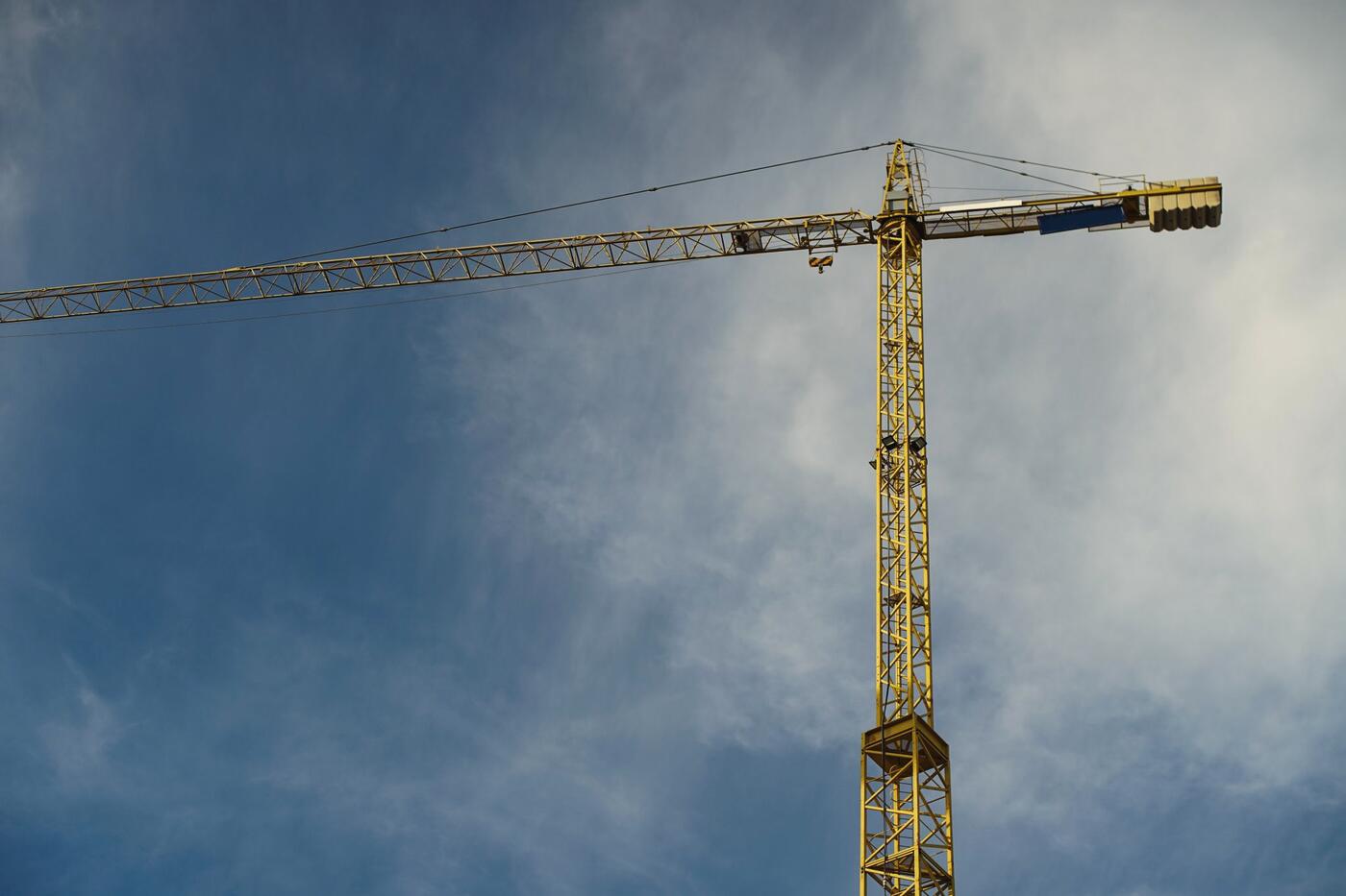 Yellow tower crane against a blue sky