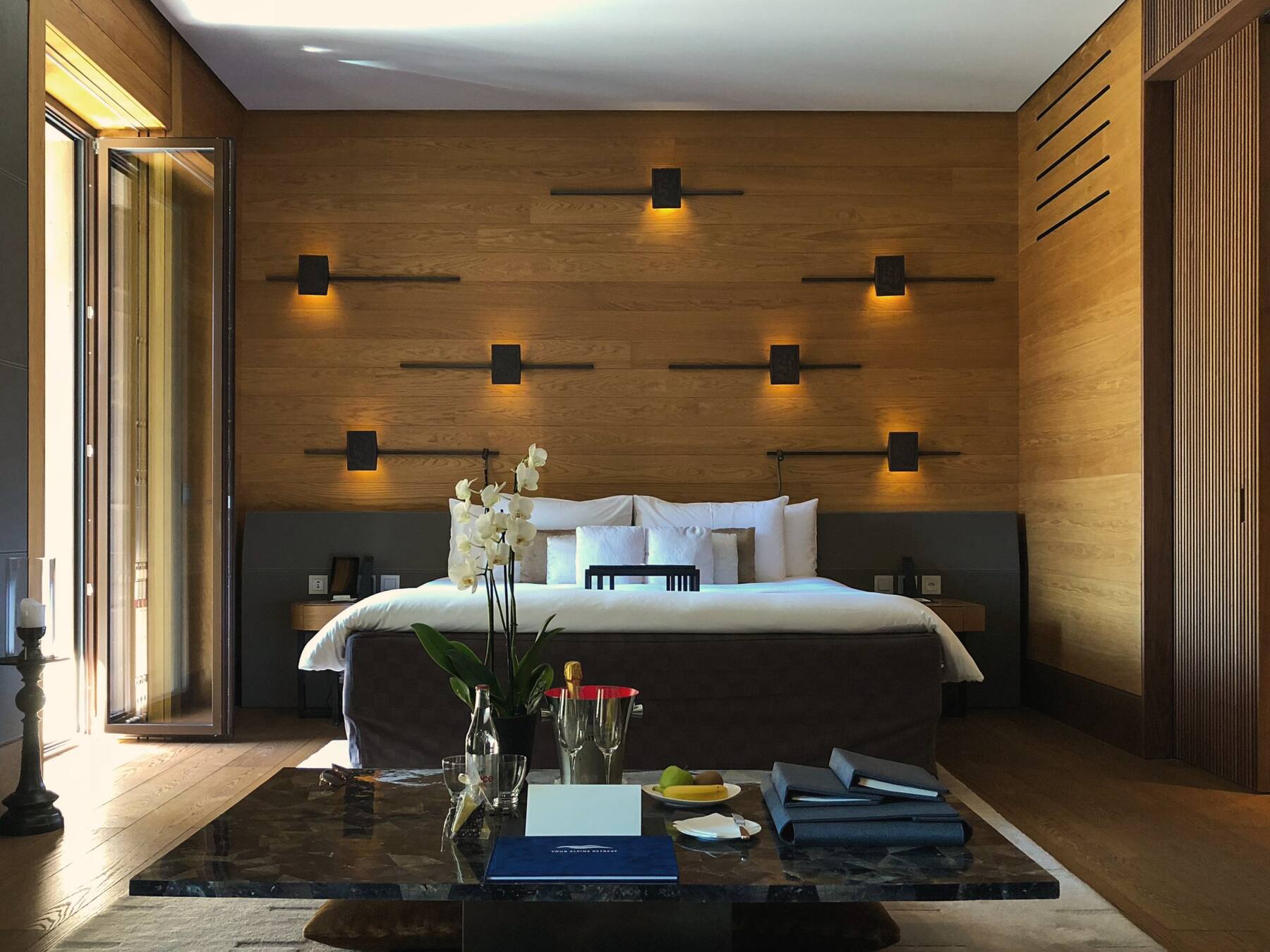 Hotel room with timber feature wall and wall lights