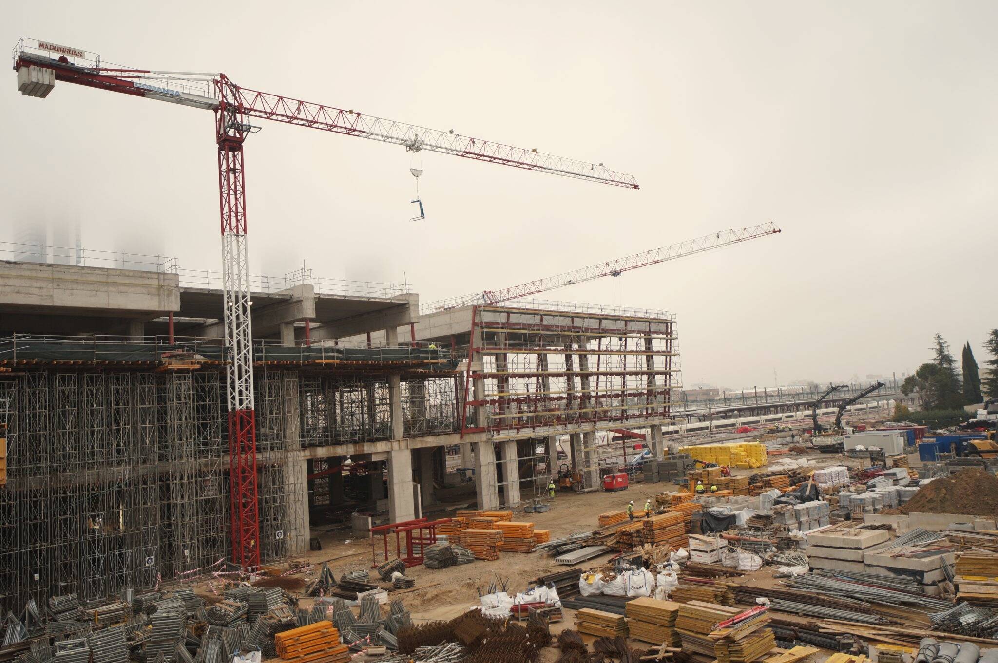 Tower cranes over a large building site on a misty morning